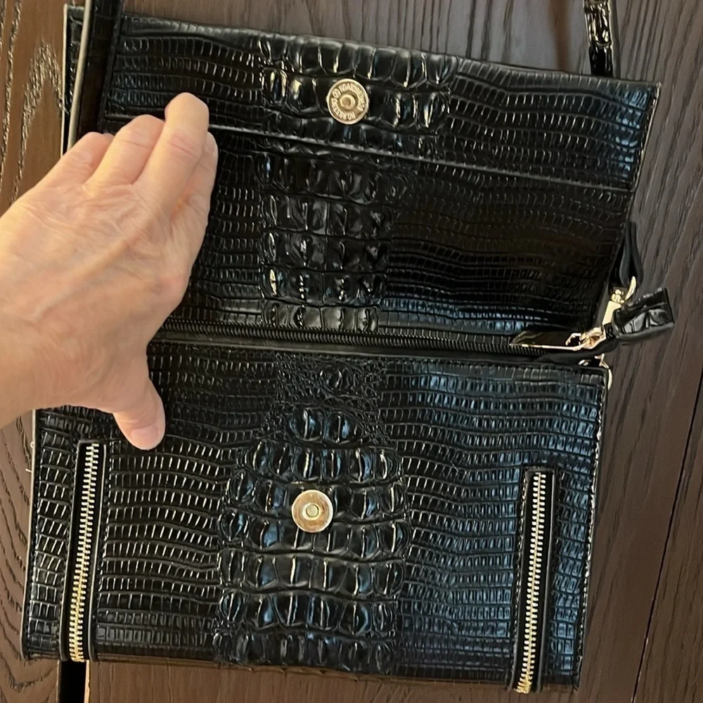 No brand black faux leather purse with black tassel and zippers for design.